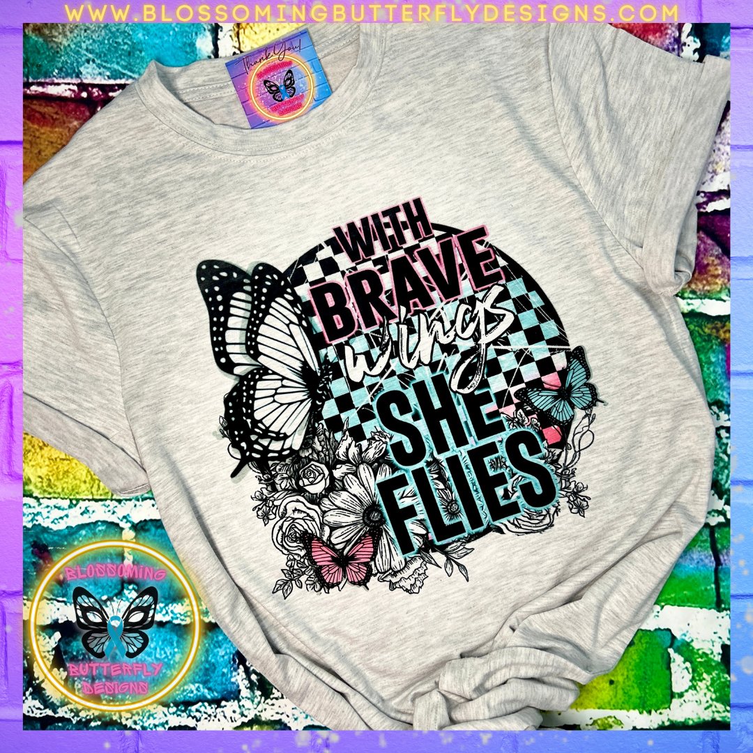 With Brave Wings She Flies tshirt on a gray shirt with butterflies and flowers